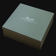 an open box with the lid closed on a black background, containing a logo for bran & butcher