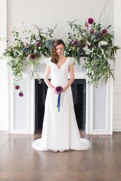 a woman standing in front of a fireplace with flowers