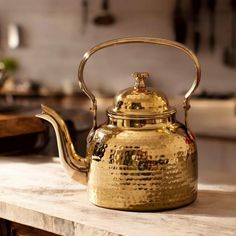 a gold tea kettle sitting on top of a counter