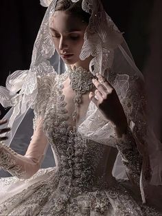 a woman in a wedding dress with an elaborate veil