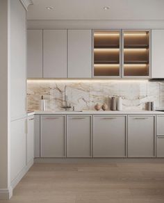 a kitchen with white cabinets and marble counter tops on the wall, along with wooden flooring