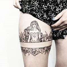 a woman's thigh with a tattoo on it and flowers around her waist,