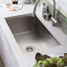 a stainless steel sink in a white kitchen