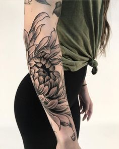 a woman's arm with a flower tattoo on the left side of her body