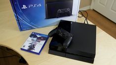 the playstation 4 console is next to its box