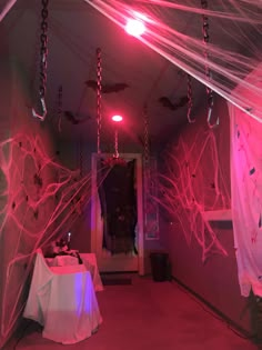 the room is decorated in pink and white with spider webs hanging from the ceiling