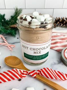 hot chocolate mix in a jar with marshmallows and candy canes around it