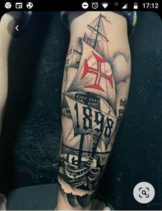 a man's leg with a ship tattoo on it