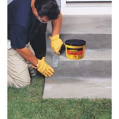 a man in yellow gloves painting the steps