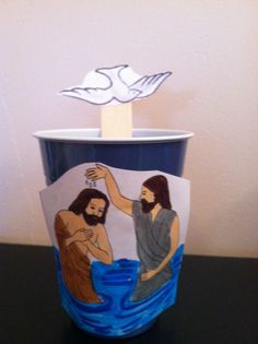 a cup that has some paper on it with jesus and mary in the water inside