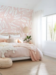 a bedroom with pink and white decor on the walls