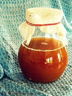 a jar filled with liquid sitting on top of a blue blanket