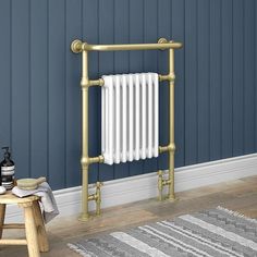 a bathroom with blue walls and white radiator next to stool, towel rack and rug