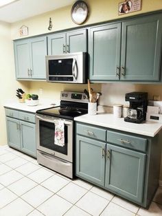 a kitchen with blue cabinets and silver appliances