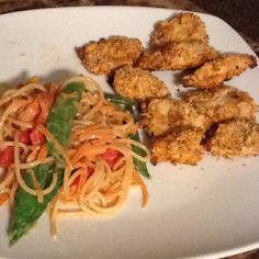 a white plate topped with pasta and chicken nuggies