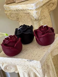 three roses sitting on top of a white table