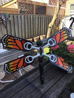 a butterfly shaped planter sitting on top of a wooden table next to a bench