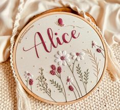 a close up of a embroidery on a piece of cloth with the word alice written in it