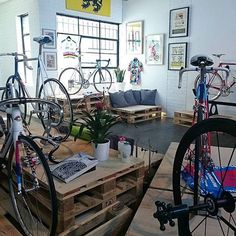 there are many bikes that are on display in this room with wood pallets around them