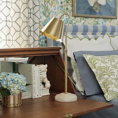 a bed room with a neatly made bed and a lamp on top of the night stand