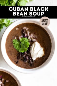 two bowls of black bean soup with sour cream and cilantro garnish