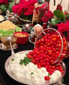 a table topped with lots of different types of food on plates and serving utensils