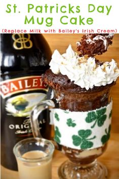 there is a mug cake with whipped cream in it and a bottle next to it