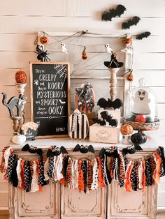 an old dresser decorated for halloween with black, orange and white decorations on the top