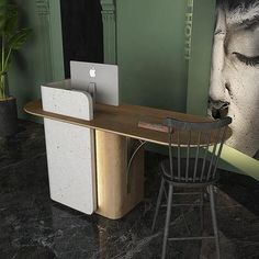 a computer desk with a laptop on top of it next to a chair and potted plant