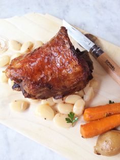 a piece of meat and some vegetables on a cutting board