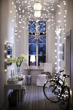 a bicycle parked in front of a window with christmas lights hanging from it's sides