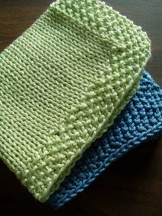 two crocheted dishcloths sitting on top of a wooden table