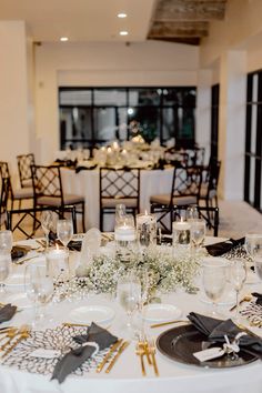 the table is set with white and black place settings