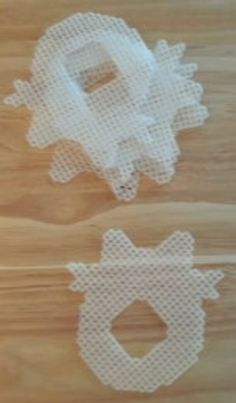 two pieces of white mesh sitting on top of a wooden table