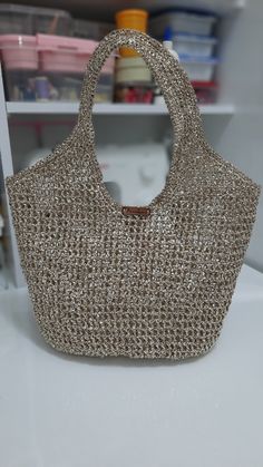 a handbag sitting on top of a white counter next to a shelf filled with craft supplies