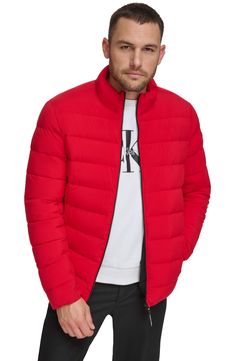 A tall stand collar structures this weather-ready puffer jacket crafted from stretch quilted fabric. Stand collar Long sleeves 100% Sorona polyester
 Machine wash, tumble dry Imported Model stats: 6'1" height, 32" waist. Model is wearing size Medium. Red Nylon Puffer Jacket For Fall, Fall Red Nylon Puffer Jacket, Calvin Klein Nylon Winter Outerwear, Casual Red Down Puffer Jacket, Red Nylon Puffer Jacket For Cold Weather, Red Down Puffer Jacket For Fall, Calvin Klein Long Sleeve Puffer Jacket For Fall, Calvin Klein Puffer Outerwear For Cold Weather, Calvin Klein Long Sleeve Winter Puffer Jacket