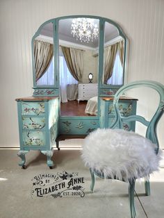 a bedroom with a vanity, mirror and chair in the room that is decorated in pastel colors