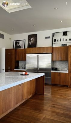 a large kitchen with wooden cabinets and marble counter tops, along with wood flooring