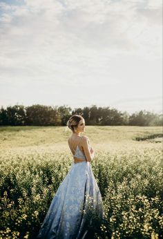 a woman in a dress standing in a field