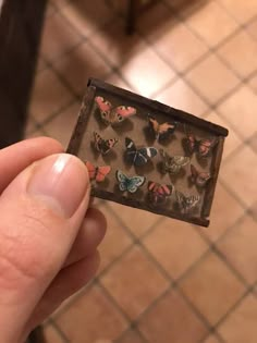 a person holding up a small box with butterflies on it