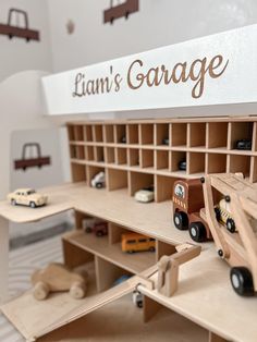 there is a toy garage with cars and trucks on the shelves in front of it