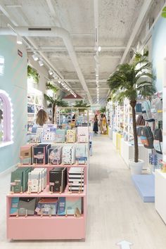 the inside of a book store with many books on shelves and palm trees in the background