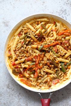 a pan filled with pasta and vegetables on top of a table