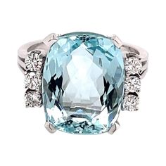 an aqua and white topazte ring with diamonds on the sides, set in 18k white gold