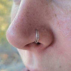 a close up of a person's nose with a ring on top of it