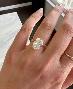 a woman's hand with a ring on it and a diamond in the middle