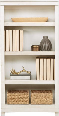 a white book shelf filled with books and wicker baskets