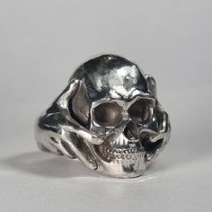 **Please note we dispatch weekly on Tuesdays**  Large sterling silver skull in hands ring This is a beautiful large ring! Weighty and a real statement piece.  Original design carved in wax then lost wax cast into solid recycled sterling silver. Large piece which weighs approximately 28g in silver. Also available blackened/oxidised finish, or in any other precious metal.  IF SELECTING THIS RING IN GOLD PLEASE NOTE THAT GOLD RINGS ARE MADE TO ORDER, ARE NON-RETURNABLE, AND THAT DISPATCH WILL TAKE APPROXIMATELY 8 WEEKS. First class signed for post included, with a supplement for special delivery. Unique Silver Skull Rings, Unique Sterling Silver Skull Ring With Polished Finish, Symbolic Hand Cast Skull Ring, Unique Hand Cast Skull Rings, Luxury Hand Cast Sterling Silver Skull Ring, Collectible Hand Cast Skull Rings, Black Sterling Silver Hand Cast Skull Ring, Hand Cast Gothic Skull Ring In Sterling Silver, Hand Cast Sterling Silver Skull Ring