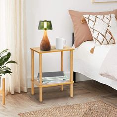 a bed room with a neatly made bed and a night stand on the side table