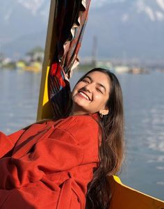 a woman smiles while sitting in a boat